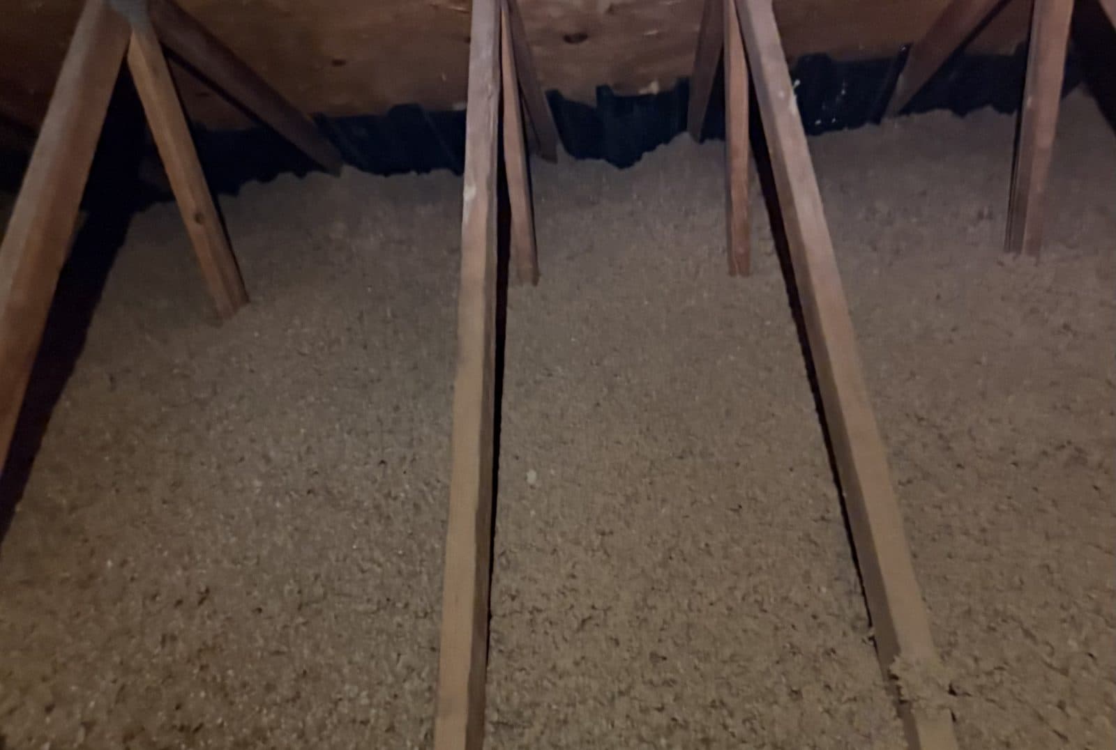 Fresh, evenly distributed blown-in insulation covering an attic floor
