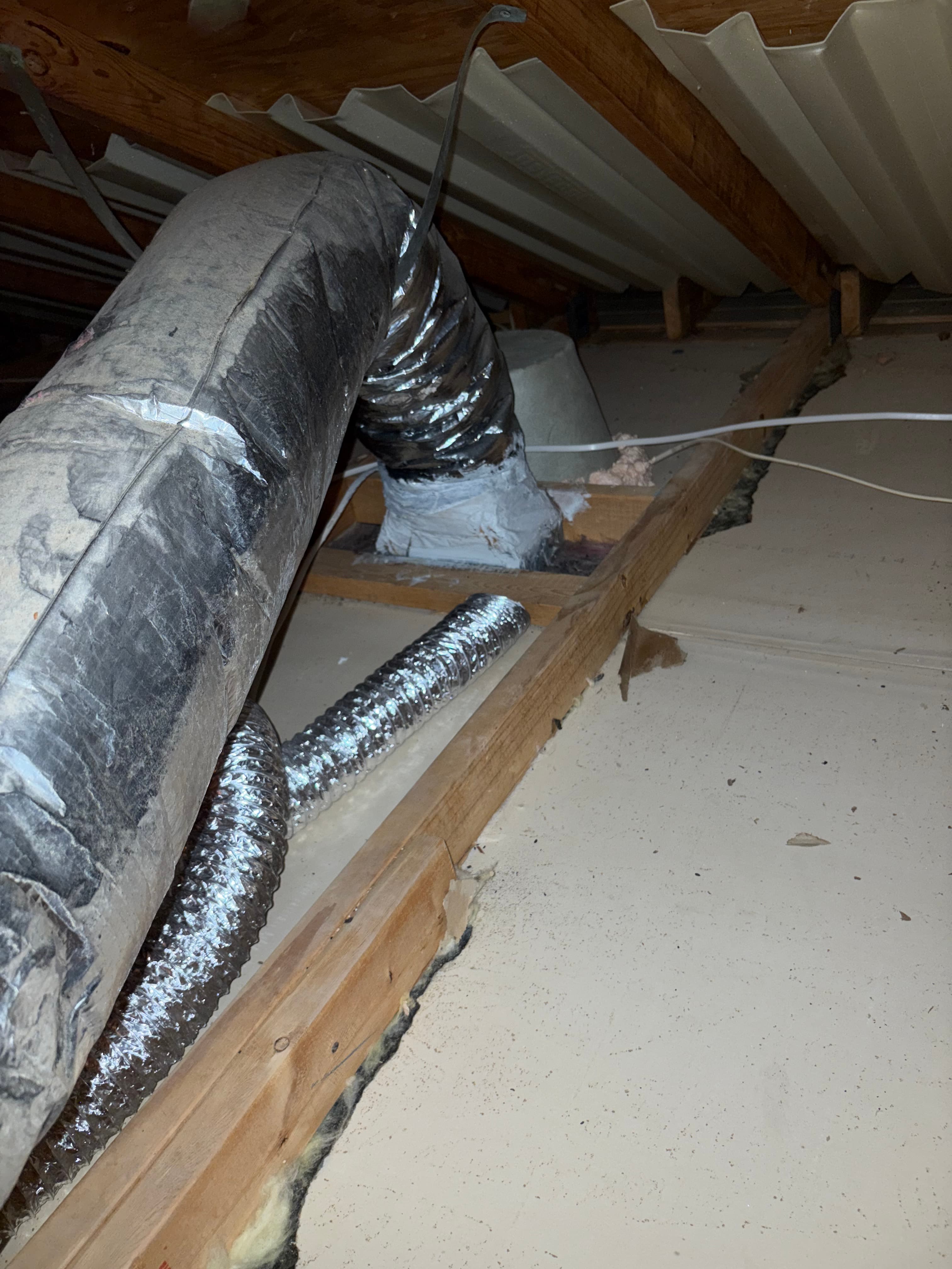 Unsealed ductwork and framing penetrations along a crawl space foundation wall
