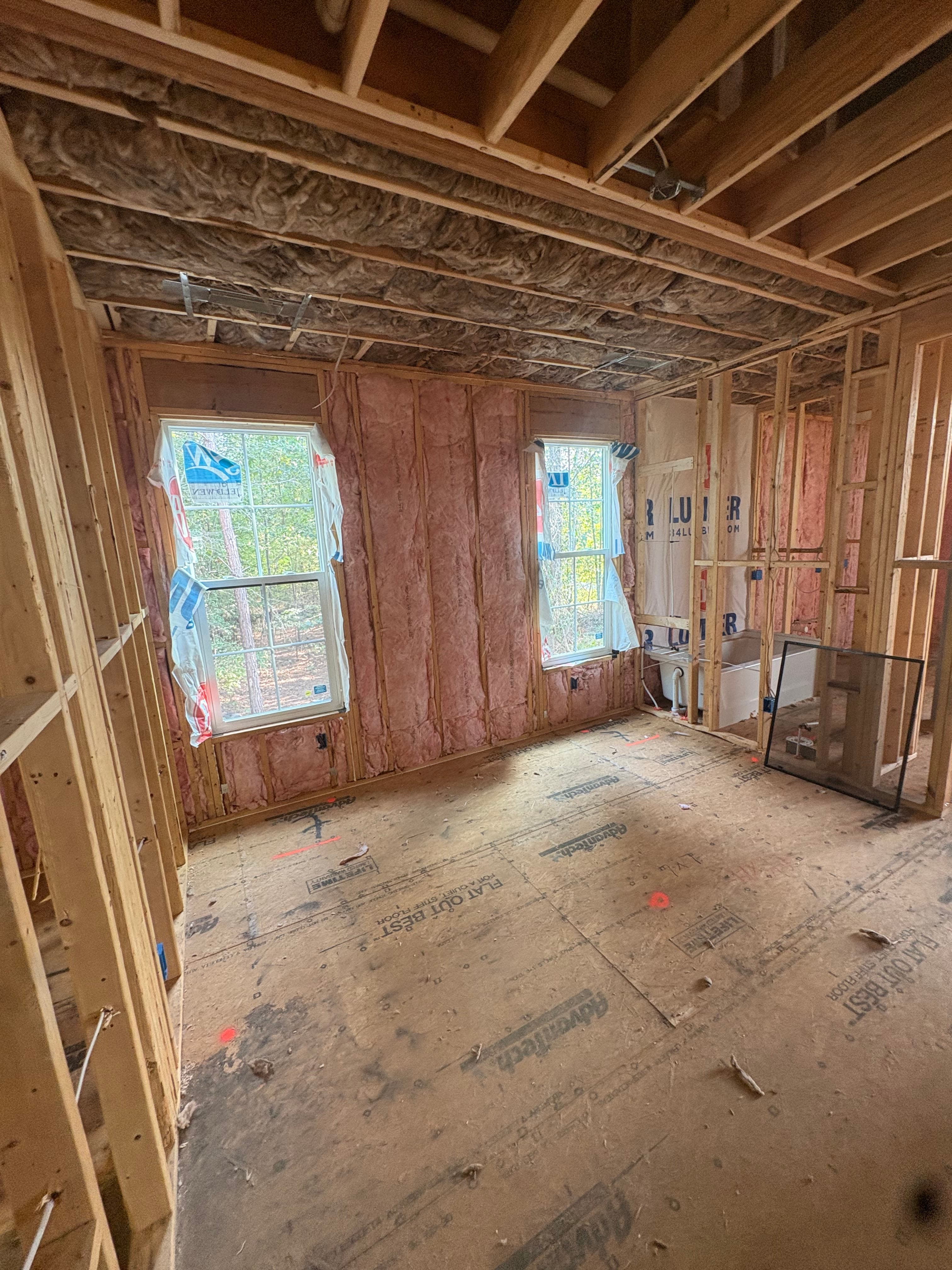 Batt insulation installed in framed exterior walls around two windows on a new-construction home